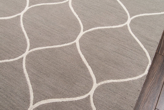 Gray textured rug with white curved lines forming irregular shapes, laid over wood flooring.