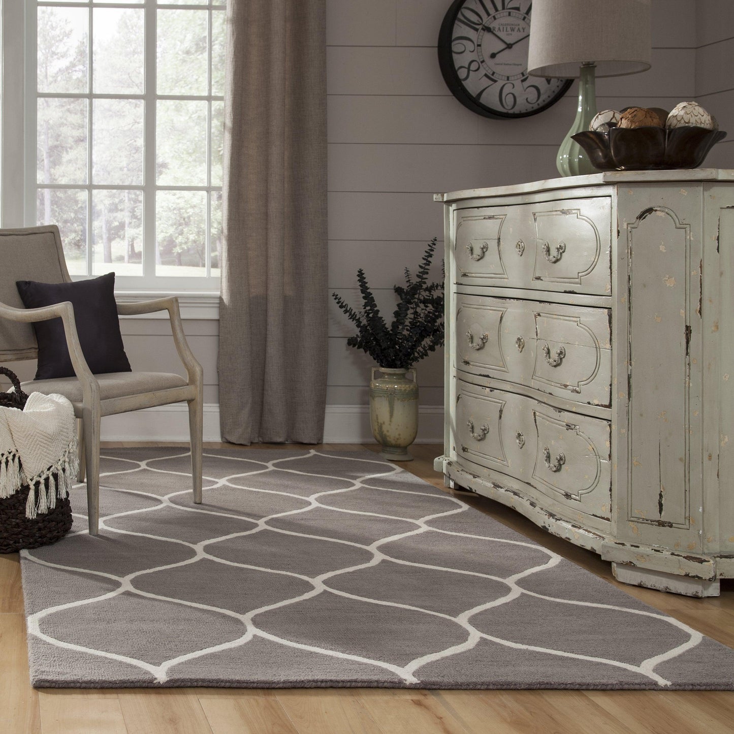 Gray lattice trellis rug on a neutral living room floor.