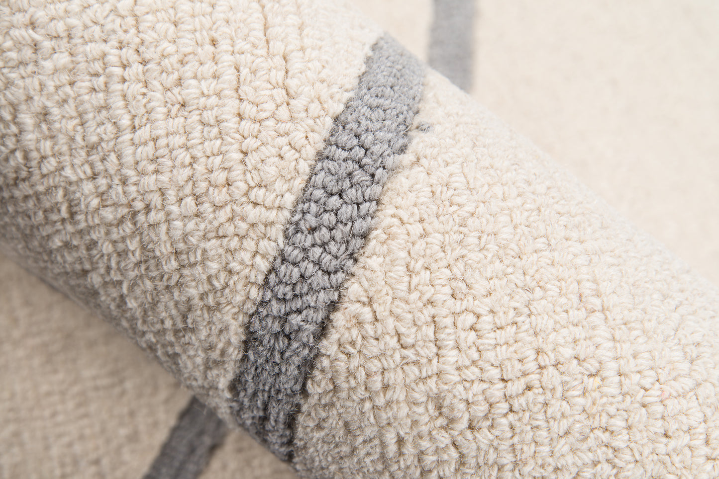 Cream sherpa fleece with a gray edge trim; plush, textured blanket or throw for cozy home decor.