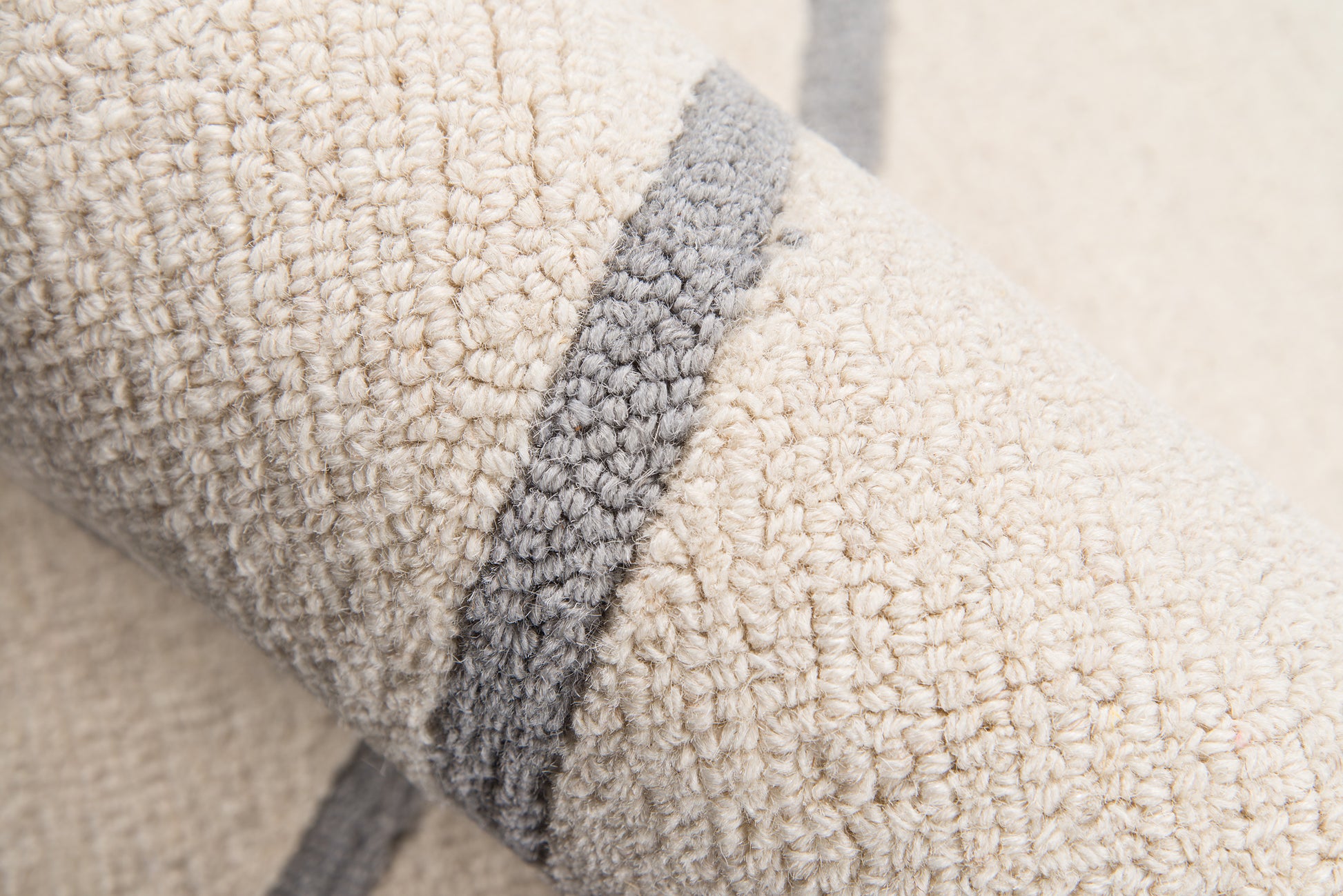 Cream sherpa fleece with a gray edge trim; plush, textured blanket or throw for cozy home decor.