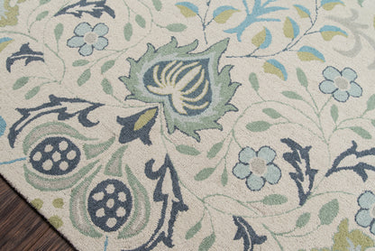 Blue-green floral patterned area rug with a beige base on dark wood floor; woven texture and vines.
