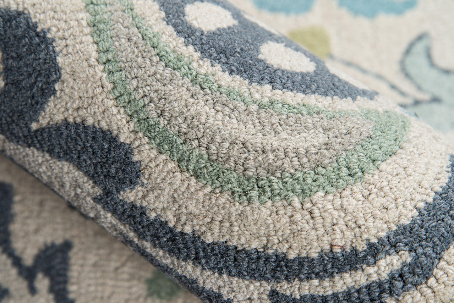 Rolled tufted geometric rug with navy, beige, sage green and light blue boucle pile.