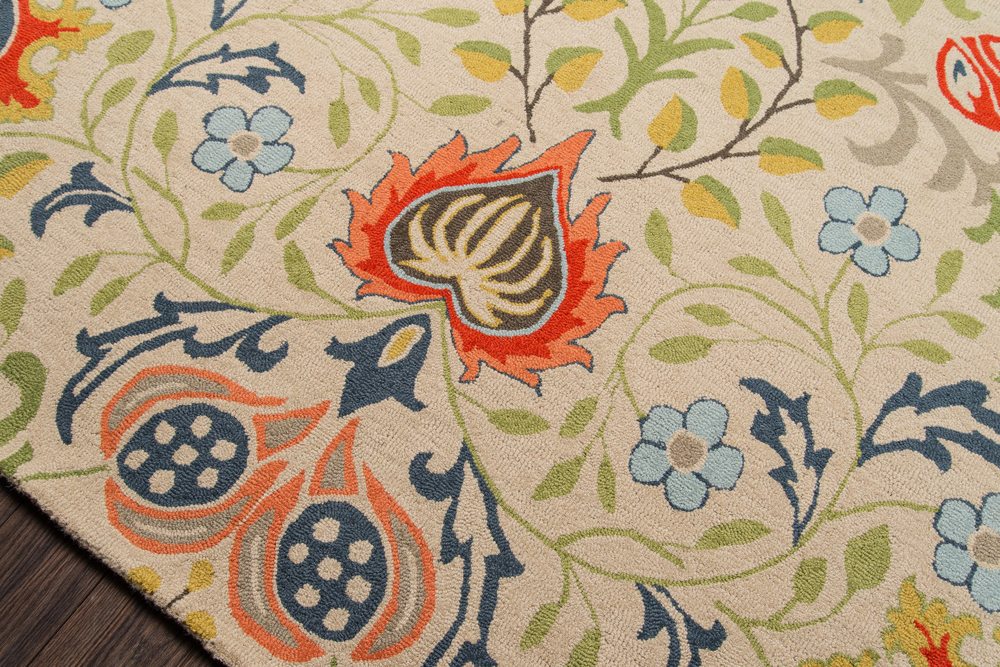 Beige area rug with multicolor botanical pattern: blue blossoms, orange-red accents, green vines; traditional style.