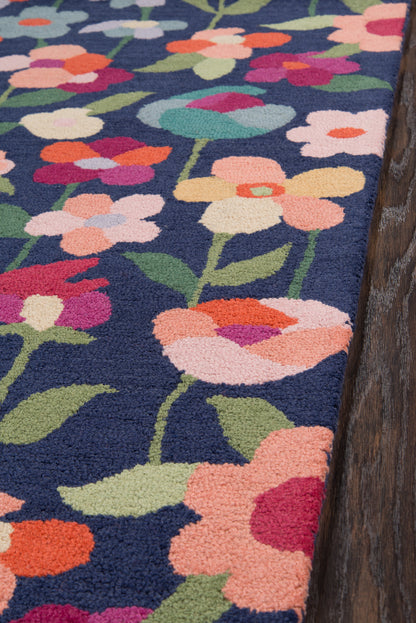 Navy floral tufted rug with bright multicolor blossoms and green stems; plush pile.
