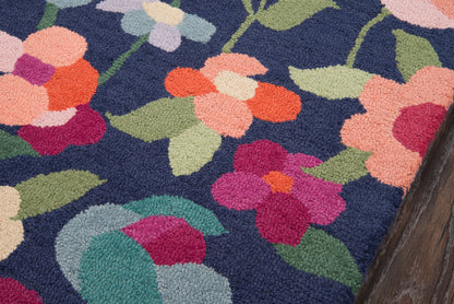 Navy shag rug with vivid pink, peach and coral flowers and green leaves in a plush floral pattern.