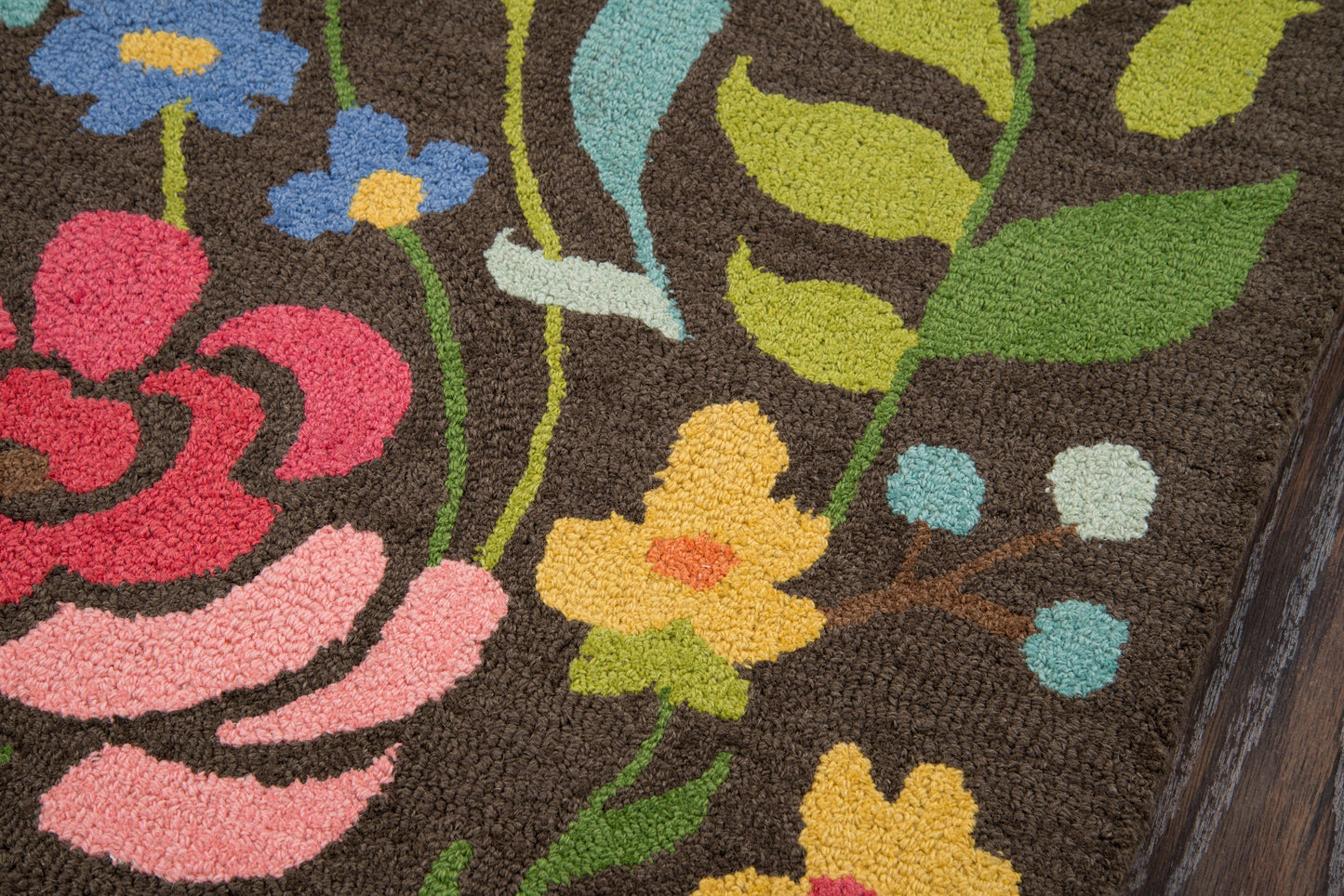 Brown floral tufted rug featuring bright yellow, pink, and blue flowers with green leaves.