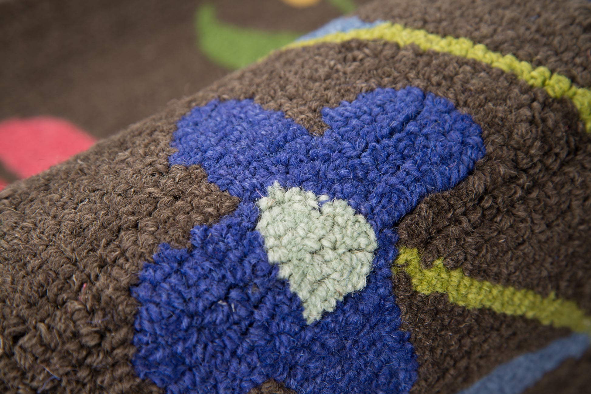 Brown shag rug with blue flower shapes and pale green centers, lime-green stripe accents.