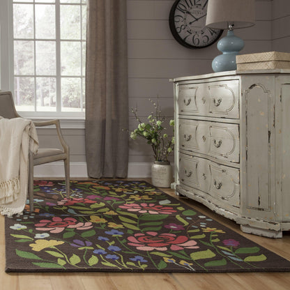 Distressed light-blue rug with a brown floral pattern featuring pink, yellow, blue flowers and green leaves.