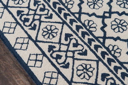 Navy & ivory runner rug with geometric floral motifs and bordered diamonds, textured pile on wood floor, size 2' x 8'.