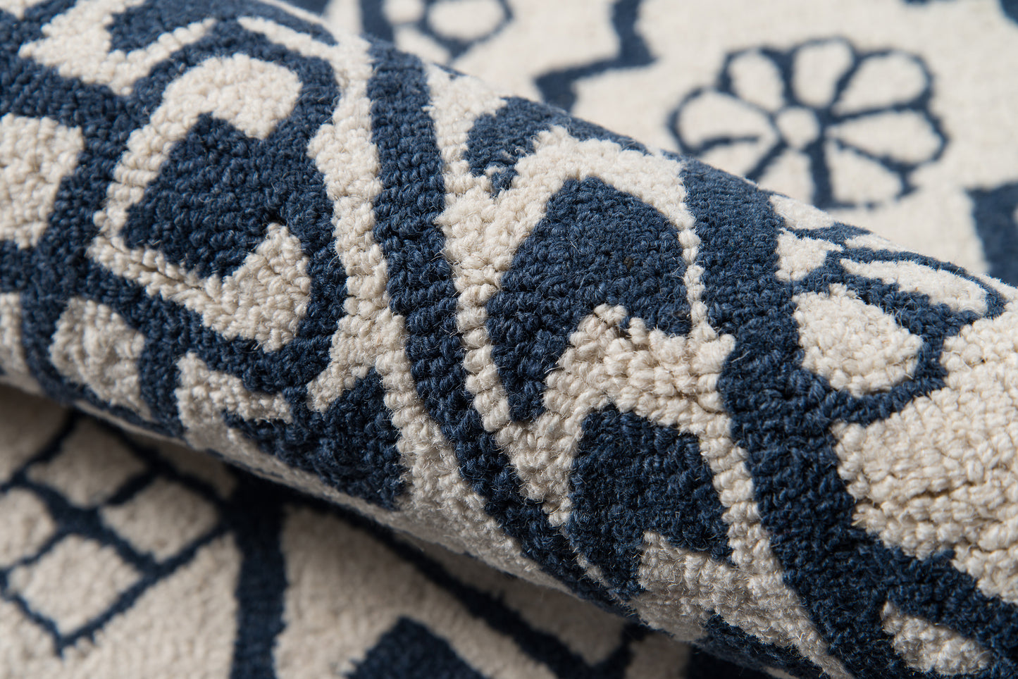 Navy blue & ivory patterned rug with plush pile, rolled edge and geometric floral motif.