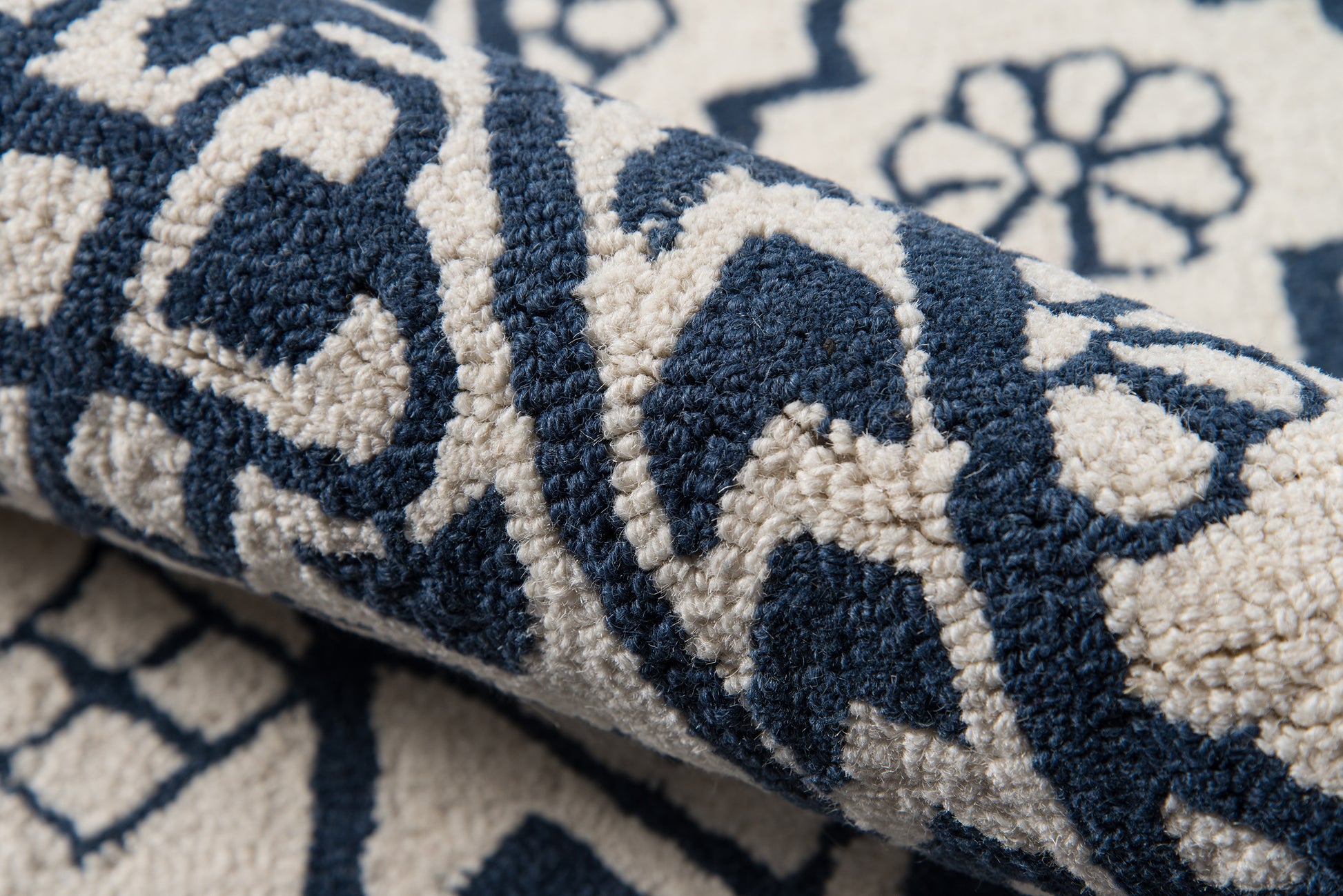 Navy blue & ivory patterned rug with plush pile, rolled edge and geometric floral motif.