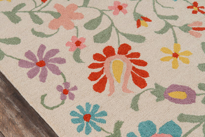 Beige floral rug with bright multicolor flowers and green vines; red, yellow, pink, purple, blue petals; wood floor edge.