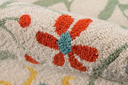 Close-up of beige textured rug with red-orange floral blossom and teal center; green vines in a traditional floral pattern.