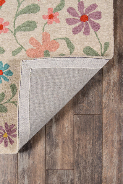 Beige floral rug with pink, purple, orange flowers and green leaves; folded corner reveals gray backing on wood floor.