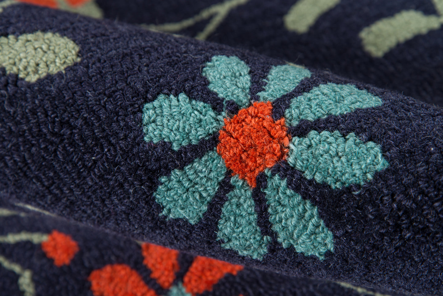 Navy terry fabric with teal floral motifs and orange centers; plush looped texture for a decorative towel or throw.