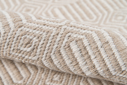 Beige and cream woven rug close-up with raised geometric pattern and chunky soft pile.