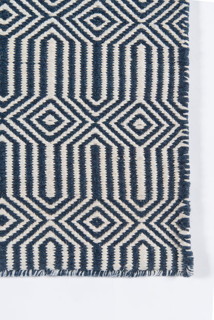 Navy & cream geometric rug with diamond & chevron motifs and a fringed edge.