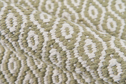 Olive green & cream geometric wool rug with a diamond motif; woven texture.