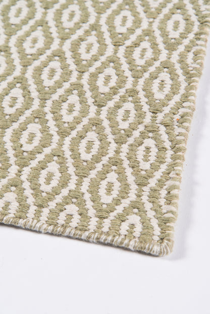 Olive green geometric rug with white diamond motifs, looped pile and bound edge.