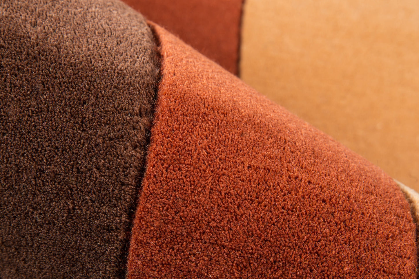 Close-up of soft wool rug fibers in dark brown and burnt orange with an overlapping weave pattern, 5'3" x 8'.