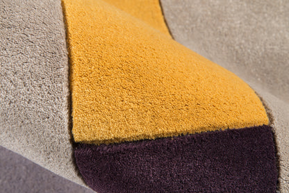 Soft boucle color-block throw in gray, mustard, and deep plum; plush, textured fabric for cozy styling.