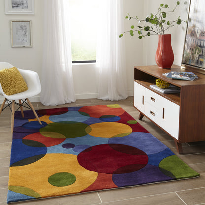 Colorful runner rug in a modern living room with white chair, wood sideboard, red vase, and sheer white curtains.