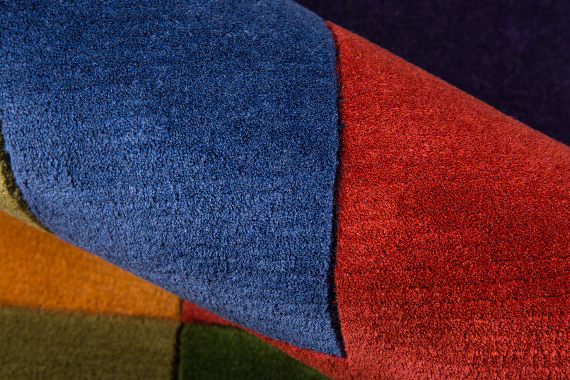 Color-block plush fleece throw in blue, red, orange, olive & mustard panels; cozy, soft blanket.