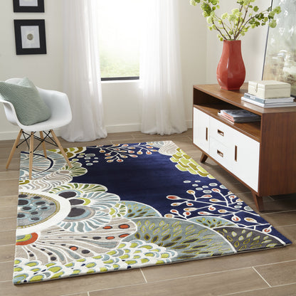 Rectangular navy area rug with abstract white, green and yellow floral leaves.