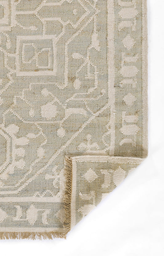 Muted blue-gray and ivory woven geometric oriental rug with fringe edge.