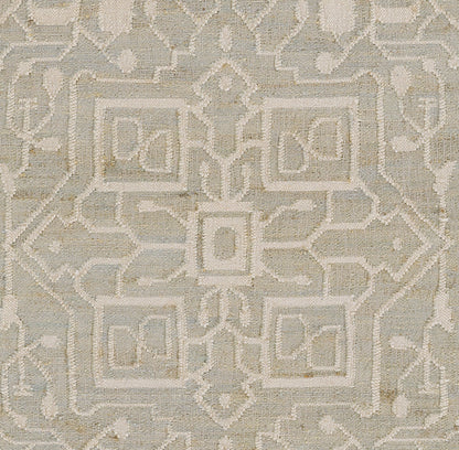 Blue-gray rug with ivory geometric motif and square medallions; tufted texture, modern traditional living room decor.