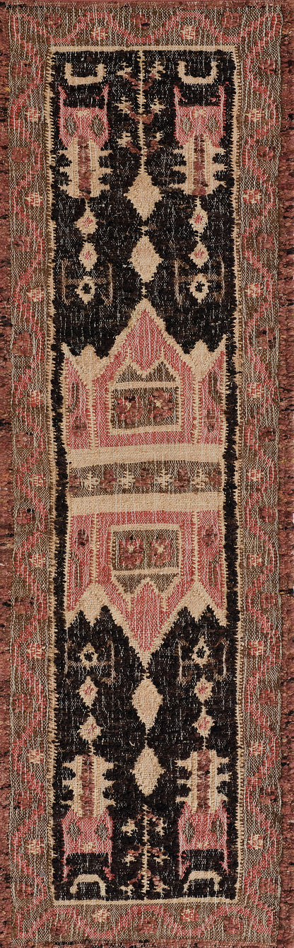 Kilim-style runner rug: long narrow with black and cream diamond motifs, pink panels, and a beige floral border.
