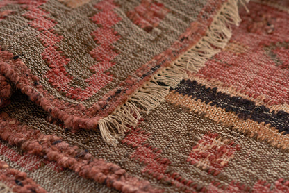 Handwoven runner rug with earthy red, brown, tan stripes, textured weave and beige fringe along edges.