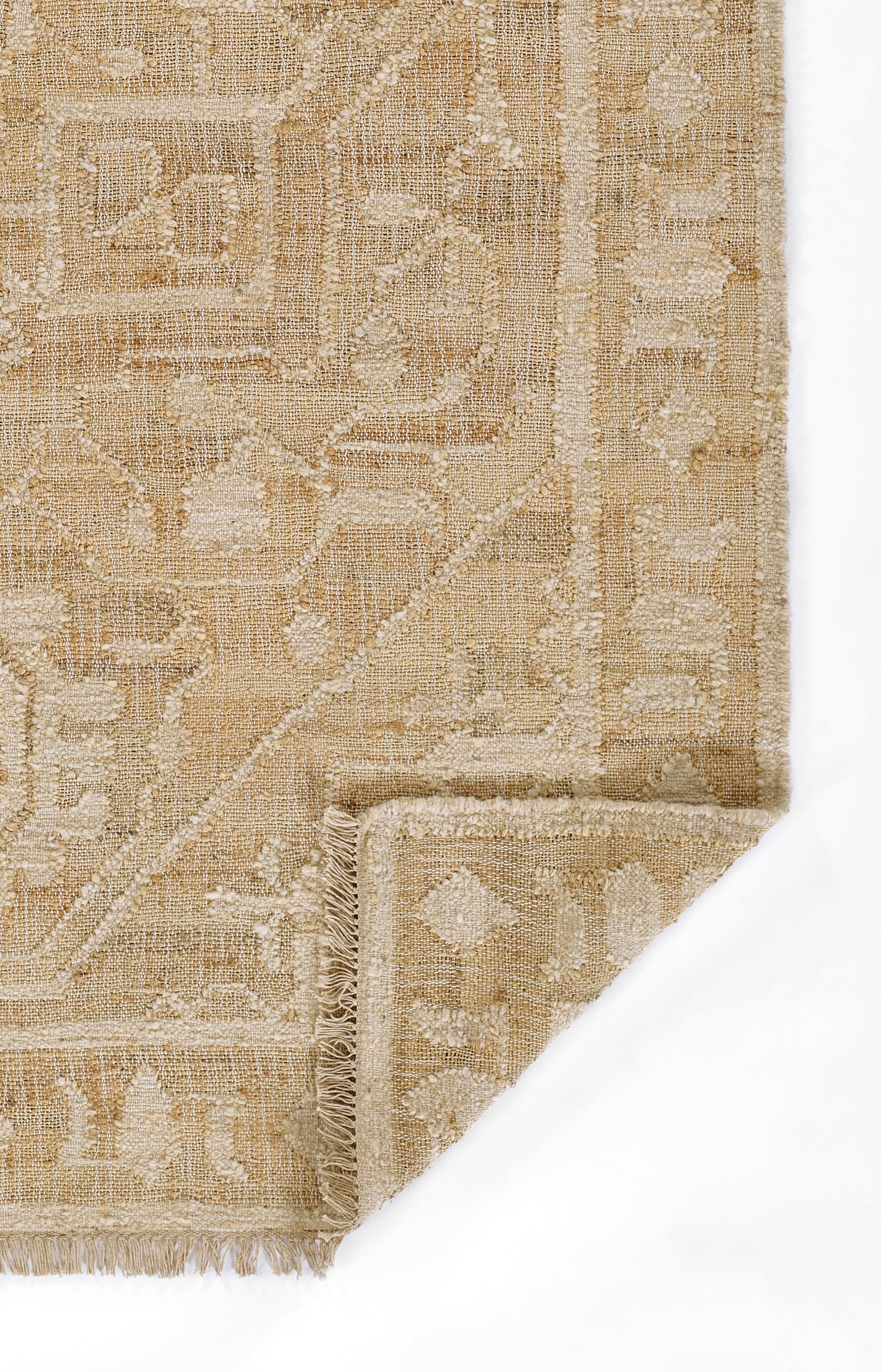 Beige woven rug with ivory geometric border and medallion motifs, fringed edge, folded corner.