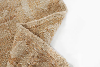 Beige and tan woven rug with textured boucle pile and fringed edges, kilim-style geometric pattern.