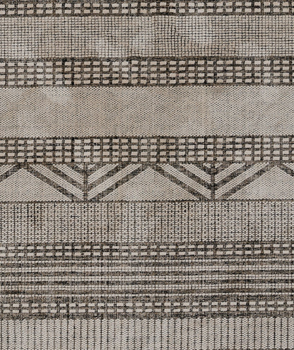 Beige-gray woven rug with black geometric grids and chevron stripe pattern; textile texture, 2' x 3'.