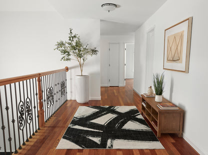 Rectangular cream runner rug with bold black abstract brushstroke pattern, modern hallway decor on hardwood floor.