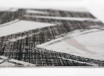 Geometric black, gray and ivory runner rug with bold angular shapes; modern low-pile rectangular design.