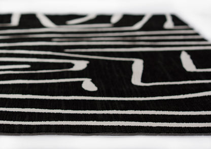 Close-up of black 2' x 8' runner rug with bold white linear stripes and abstract pattern.