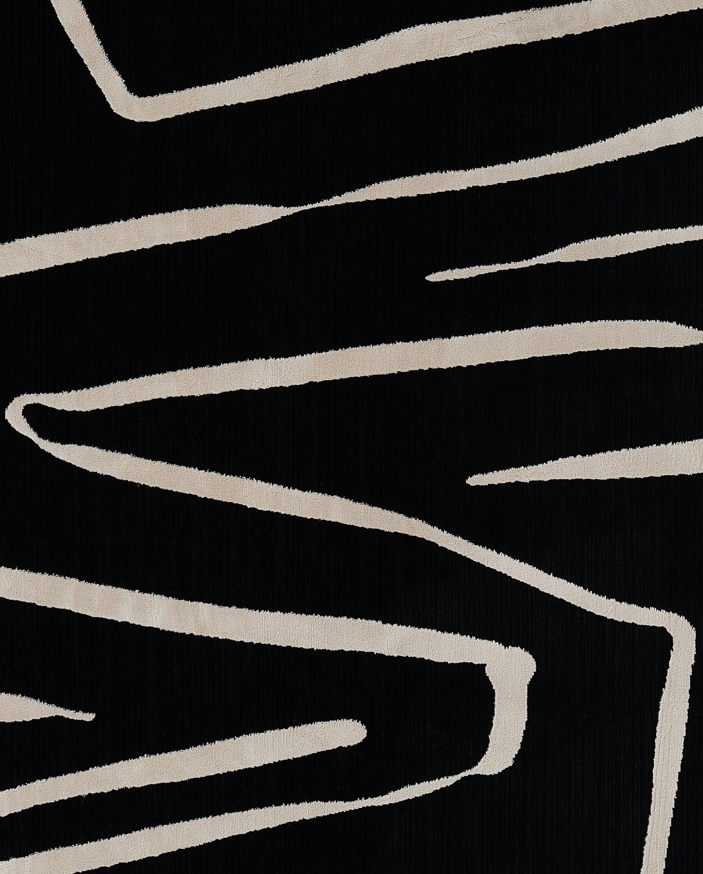 Black rug with beige abstract brushstroke lines.