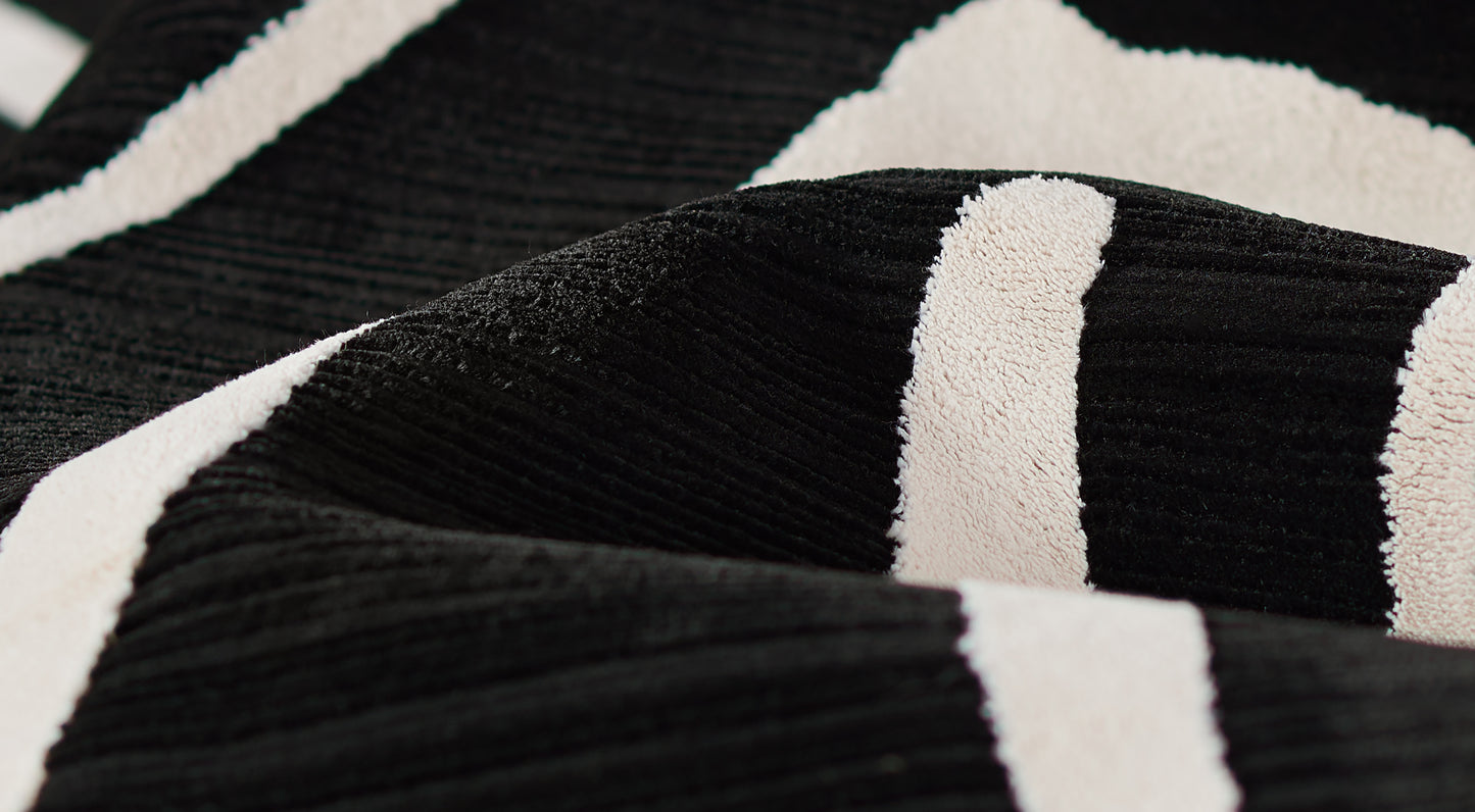 Black and white striped rug with plush, ribbed texture, 5' x 8'.
