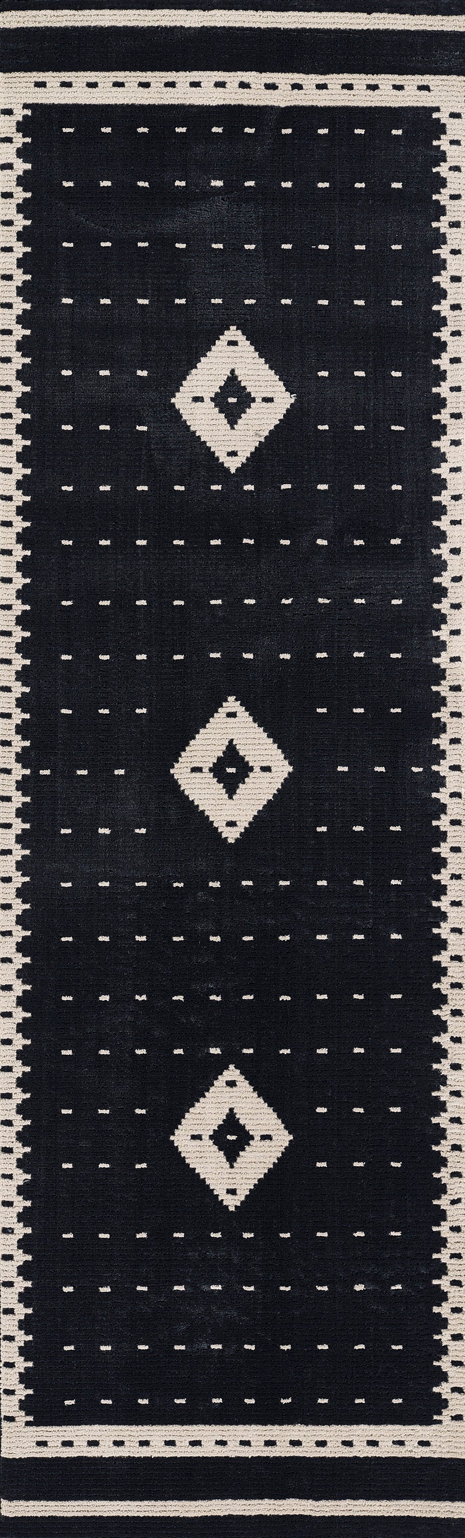 Navy geometric rug with cream border & three white diamond motifs & dotted grid pattern.