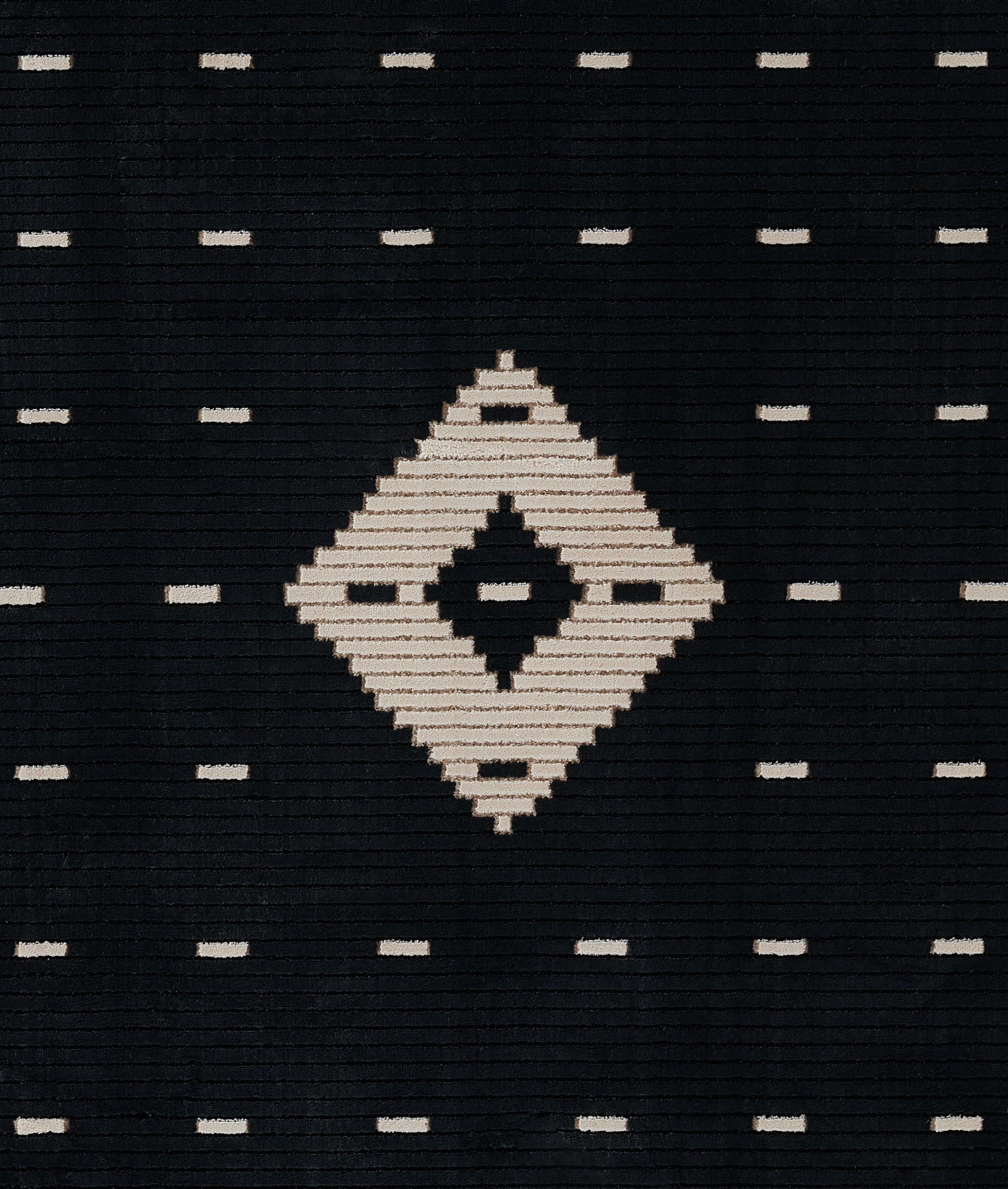Dark navy woven rug featuring a large ivory diamond center and tiny ivory dash motifs; geometric tribal-inspired textile.