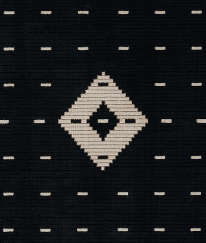 Black woven rug with cream diamond center and small cream dashes in a Southwestern geometric pattern.