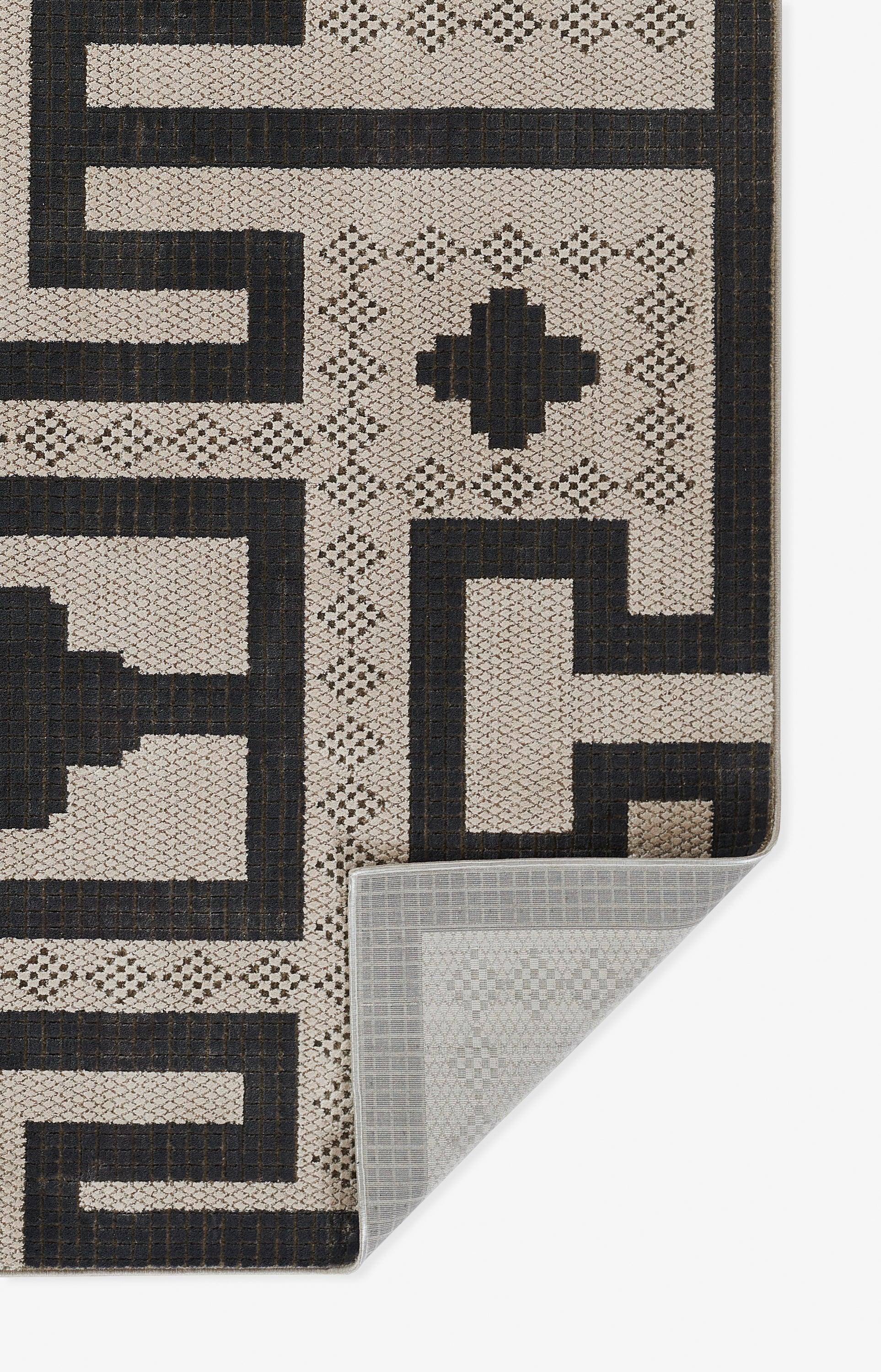 Ivory and black geometric area rug with bold border and cross motif; woven texture for modern indoor decor.