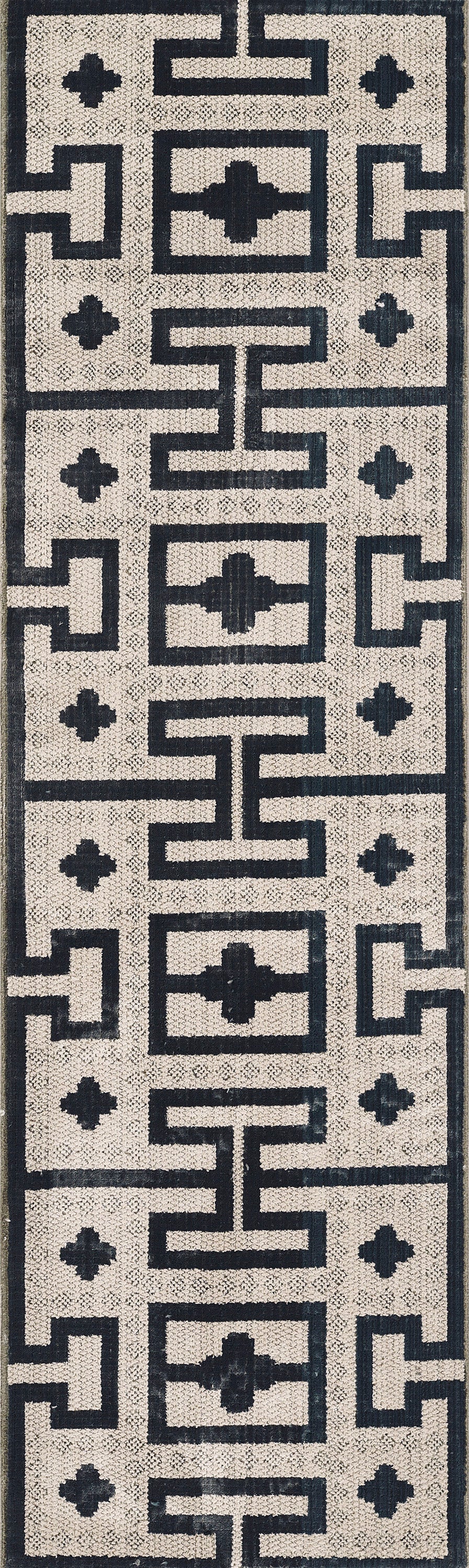 Ivory and navy geometric rug with Greek key motifs and cross accent squares; textured modern-traditional style.