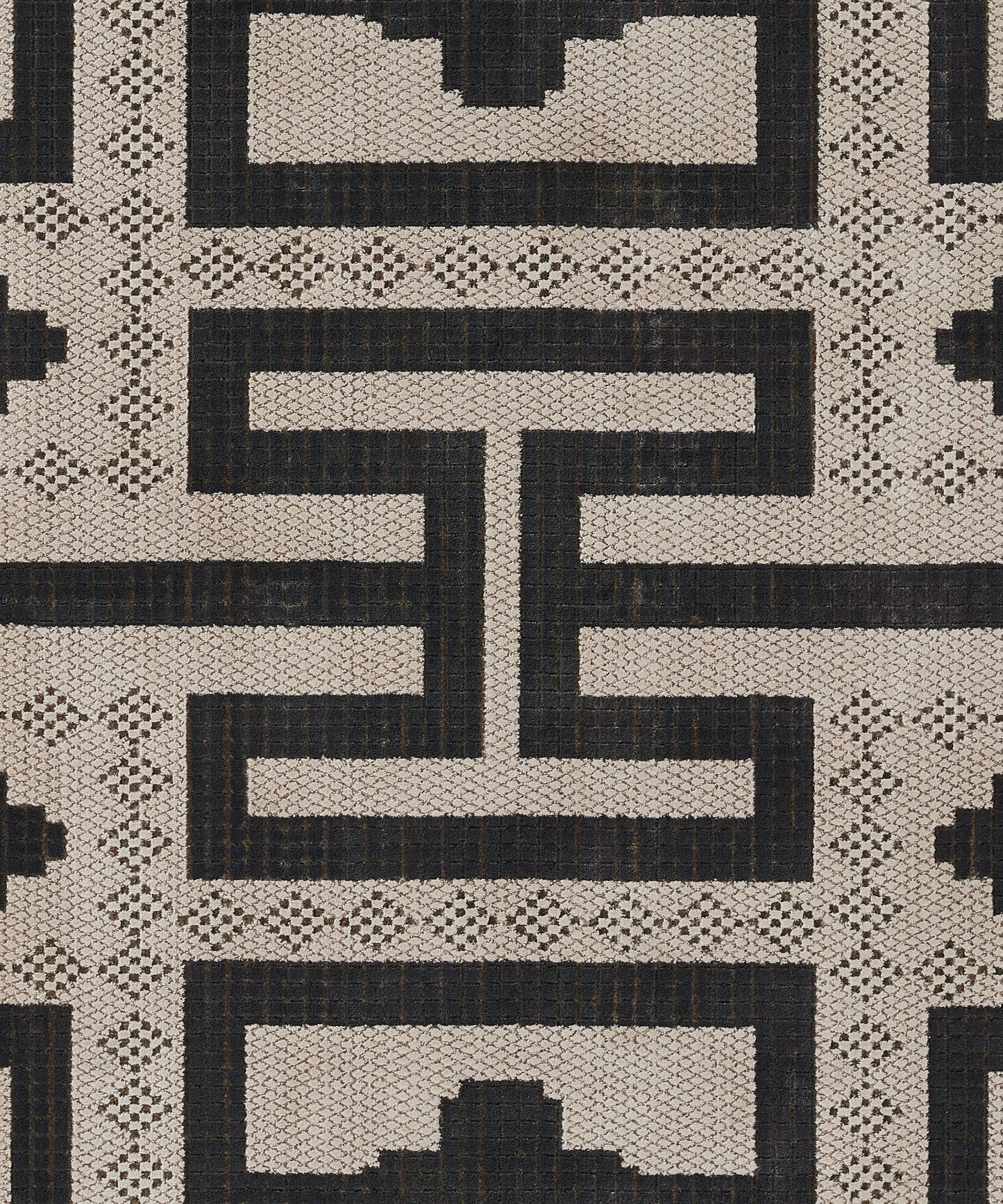 Ivory and charcoal geometric rug with interlocking Greek-key motif and dotted border in textured weave.