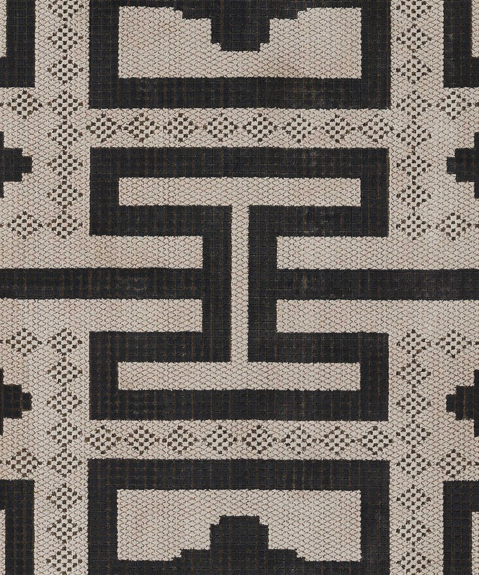 Beige and black woven rug with bold Greek-key maze motifs and lattice pattern.