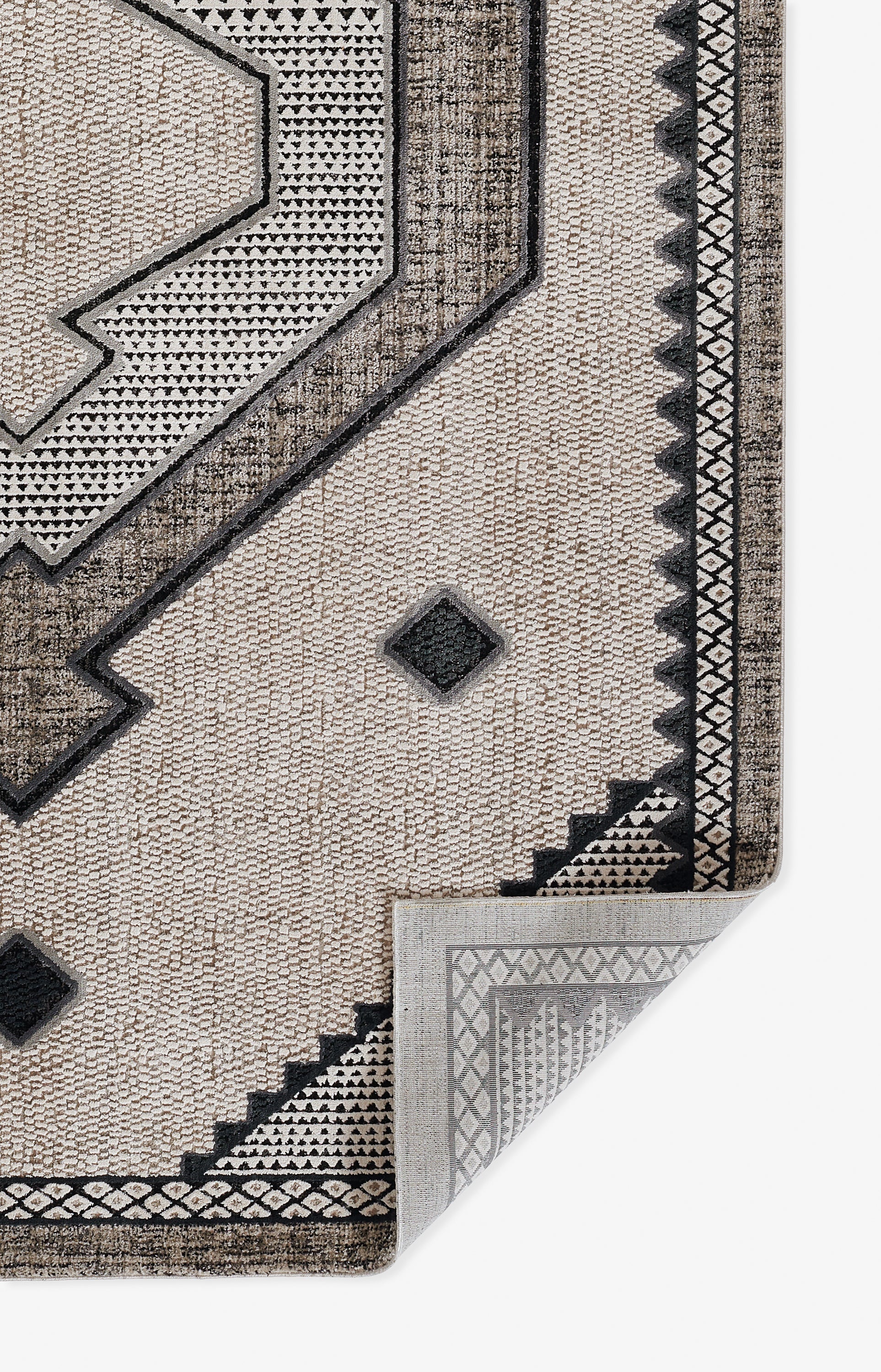 Ivory geometric woven rug with dark borders, angular shapes & diamond motifs; reversible with a lighter back.