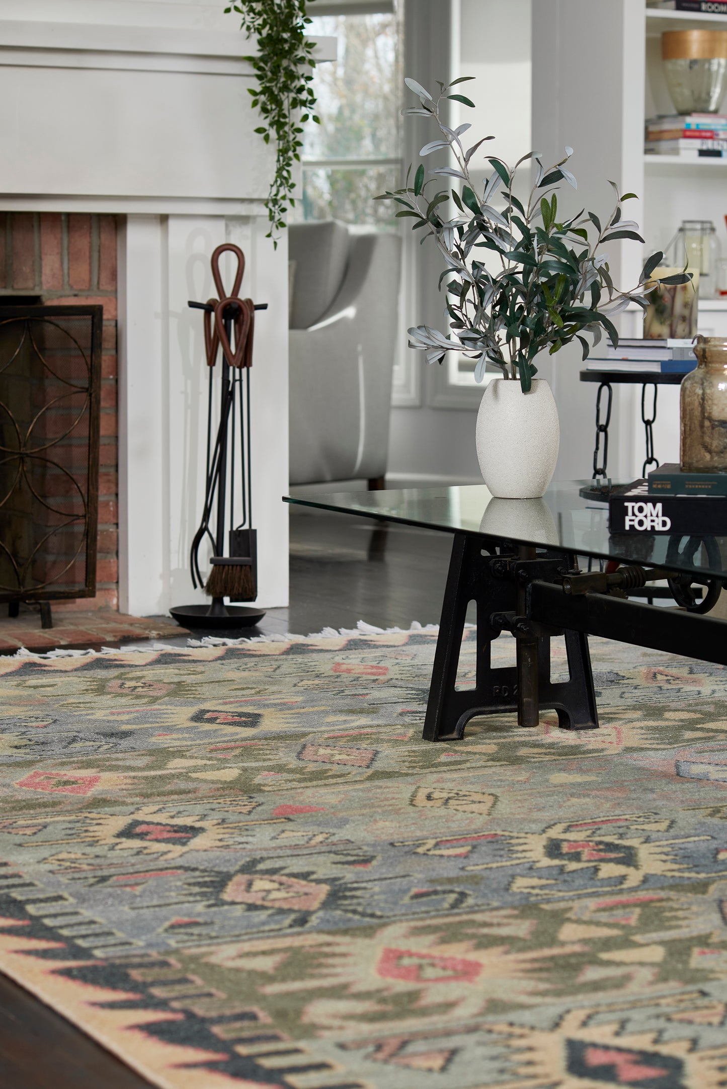 Geometric tribal area rug in muted greens, blues, pinks and beiges; woven kilim-inspired pattern for living room decor.