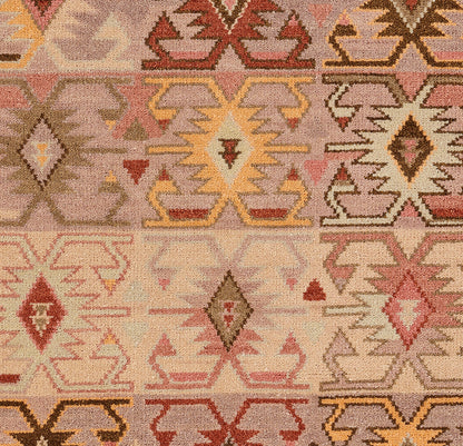 Geometric kilim-style rug with diamond and zigzag motifs in pink, peach, beige, yellow, and brown.